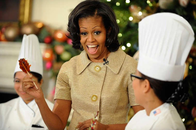 Image: U.S. first lady Obama holds a lollipop made of tea and honey that she had decorated with sugar icing and candied carrots in the State Dining Room, during the first viewing of the 2012 holiday decorations at the White House in Washington